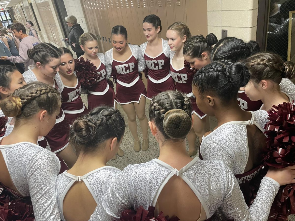 Poms team huddle before they perform at a competition!