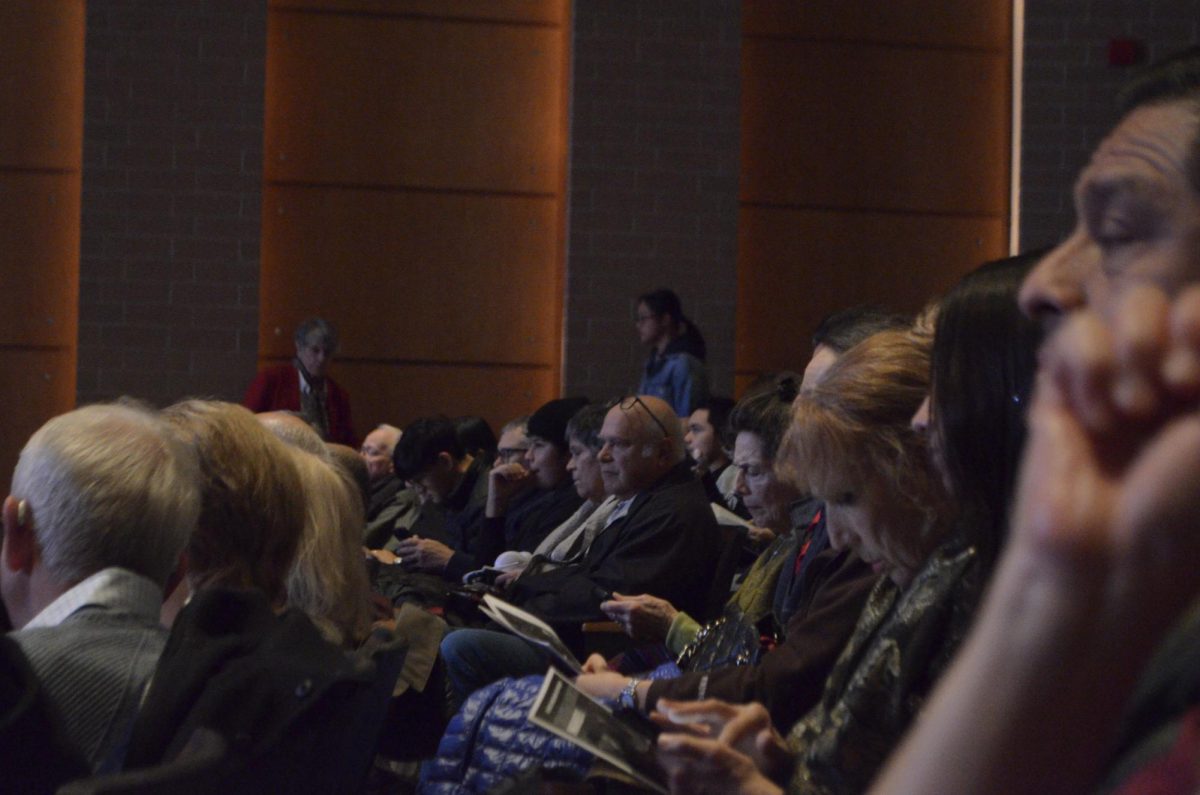 Northside student Jimi Gutierrez Clark at the far end of the row (glasses) seen reading the concert pamphlet. 